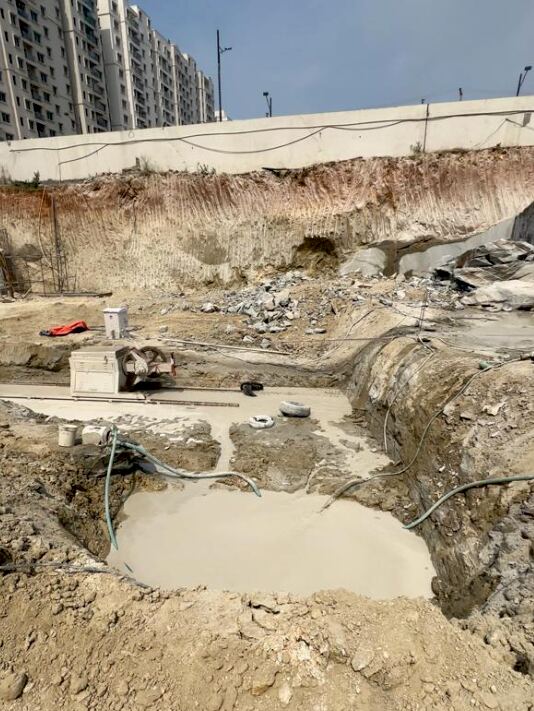 Deep excavation pit with dewatering pump in operation